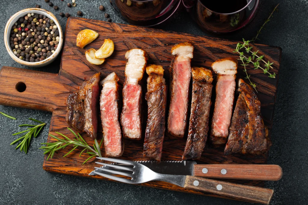 Close-up of a picanha steak on a sizzling grill, seasoned with salt and ready to be served