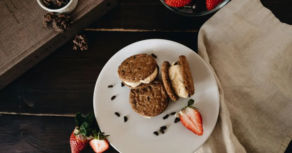 Homemade choc chip ice cream sandwich recipe with vanilla ice cream between two chocolate chip cookies.