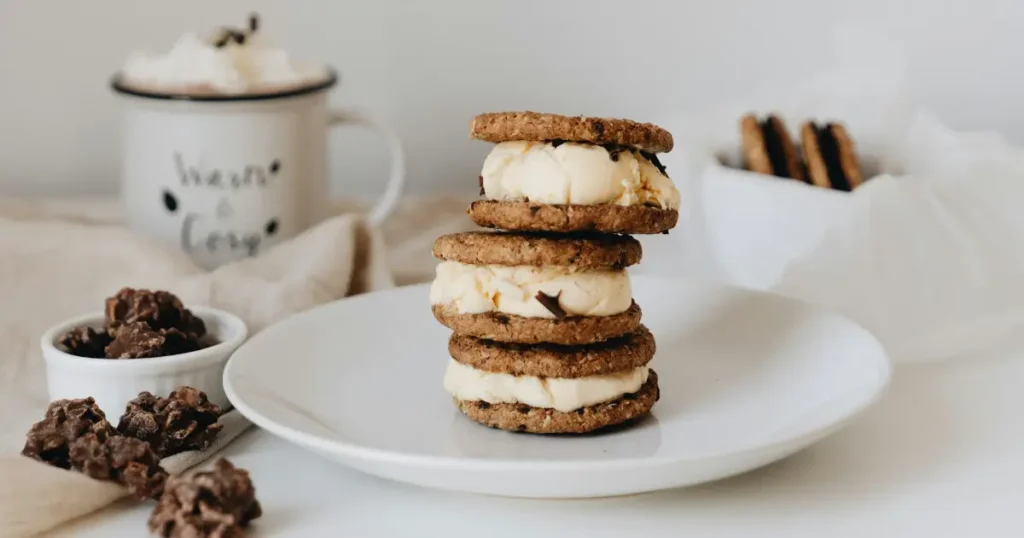 Stacked chocolate chip cookies with a scoop of vanilla ice cream on top.